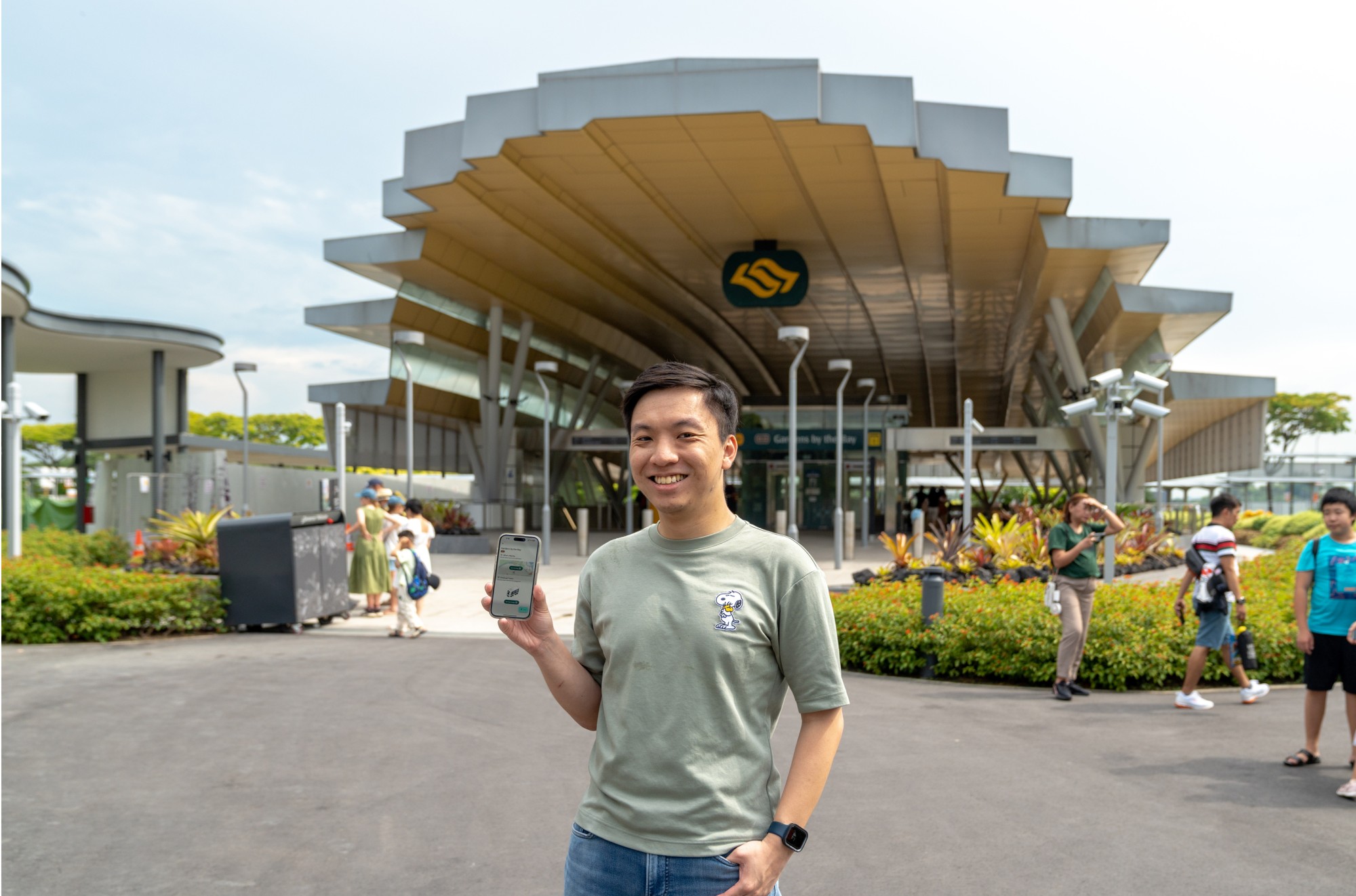 Joshua holding a phone infront of MRT Station